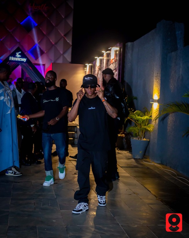 DJ Kenny in a cap and sunglasses arriving at a night event in Abuja