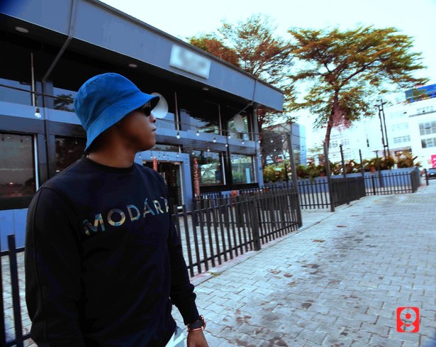DJ Kenny walking outside a venue in a bucket hat